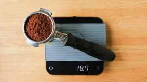 پروتافیلتر پر از پودر قهوه روی ترازو دیجیتال