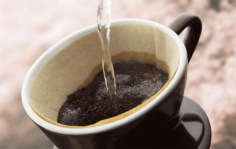 ریختن آب روی پودر قهوه برای دم آوری قهوه